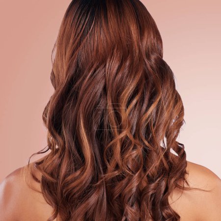 Beauty, back and hair care of woman in studio isolated on a red background for haircare. Curly hairstyle, keratin cosmetics and female model with salon treatment for growth, texture and balayage