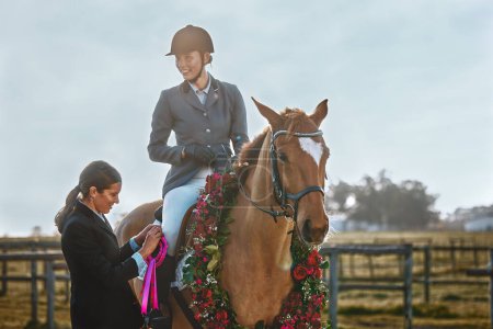 Téléchargez les photos : Woman, horse and winner of equestrian competition with ribbon award for sports achievement. Athlete person on animal for horseback riding, race and training for badge prize with pride in countryside. - en image libre de droit