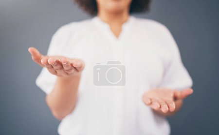 Téléchargez les photos : Woman, hands and space for choice in studio for product placement, palm and mockup or decision. Model person with hand for advertising promotion deal and brand offer or balance scale gray background. - en image libre de droit