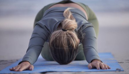 Téléchargez les photos : Woman, yoga and stretching on beach for spiritual wellness, zen or workout in nature. Female yogi in warm up stretch, shishosana pose or pilates for healthy exercise or fitness by the ocean coast. - en image libre de droit