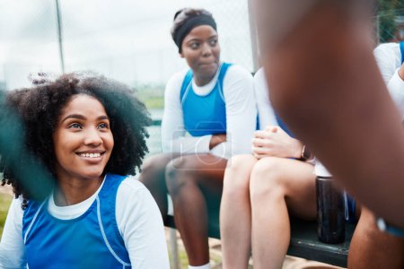 Photo for Sports, netball and women with smile talking, planning and sitting on stand for game, match and practice on court. Fitness, teamwork and happy female athletes for exercise, training and competition. - Royalty Free Image