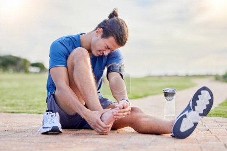 Photo for Fitness, sports injury and foot pain with man in park for muscle spasm, inflammation and joint problem. Running, workout and exercise with athlete and emergency for health, suffering and broken ankle. - Royalty Free Image