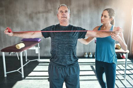 Foto de Muscle weakness doesnt have to be a thing. a senior man using resistance bands with the help of a physical therapist - Imagen libre de derechos