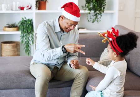 Photo for Rock, paper, scissors at Christmas with a father and daughter in the living room of their home together. Black family, love or bonding with a man and girl child playing games in their house. - Royalty Free Image