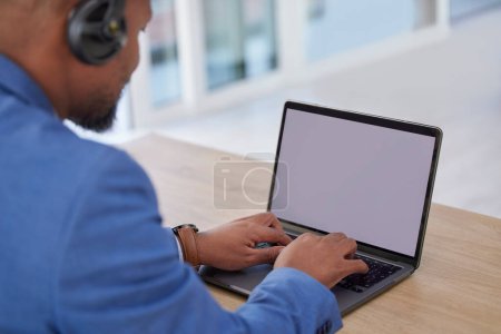 Photo for Black man, laptop and mockup screen typing with headset for business proposal, communication or marketing at office desk. African American male working on computer with display for advertisement. - Royalty Free Image