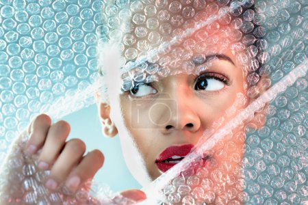 Photo for Bubble wrap, beauty and face of woman with makeup, cosmetics and skincare products in studio. Creative art deco, salon aesthetic and thinking girl with glow, lipstick and luxury style with plastic. - Royalty Free Image