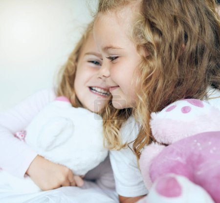 Photo for Children, love and twin sisters playing together holding teddy bear toys while lying comfortable sharing family or sibling bond at home. Happy, family and caring girls and friends in bed for fun. - Royalty Free Image