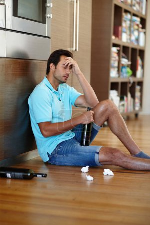 Foto de Ahogando sus penas. un hombre llorando bebiendo vino mientras está sentado en el suelo con algunos pañuelos - Imagen libre de derechos