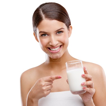 Delicious and good for you. Studio portrait of an attractive young woman pointing to the glass of milk shes holding
