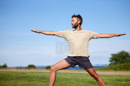 If it doesnt challenge you, it doesnt change you. a handsome mature man doing yoga outdoors