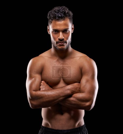 Photo for His determination got him the body he always wanted. Studio portrait of a handsome bare-chested young athlete standing against a black background - Royalty Free Image