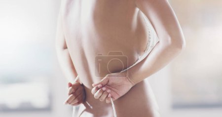 Photo for Taking it off. Rearview shot of an unrecognizable young woman removing her bra - Royalty Free Image
