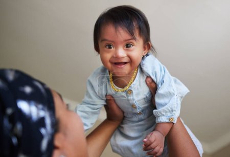 Photo for Happy, down syndrome baby and child mom care of a woman holding a kid with a disability at a house. Happiness and smile of a young toddler special needs face from India in a home with a mother. - Royalty Free Image
