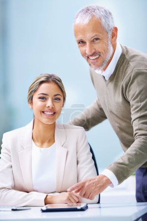Téléchargez les photos : Travail d'équipe avec un sourire. Portrait d'une jeune femme d'affaires et d'un homme d'affaires mature dans un bureau - en image libre de droit