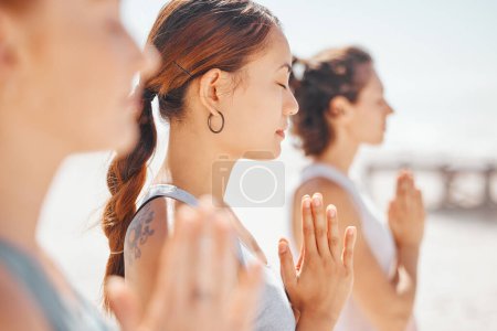 Photo for Women friends meditation while training yoga exercise on the beach. Group of zen female athlete working out outside with inner peace, balance and getting healthy or wellness on a fitness lifestyle. - Royalty Free Image