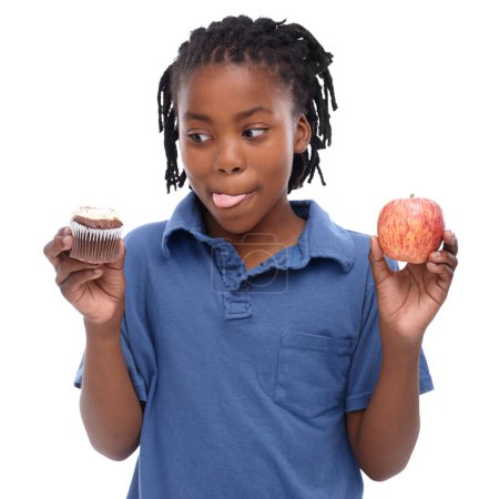 Photo for Mmmm....A young African-American boy trying to decide between an apple and a cupcake - Royalty Free Image