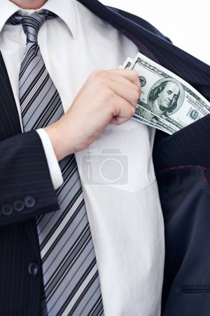Photo for Pocketing company money. a businessman placing money into his pocket - Royalty Free Image
