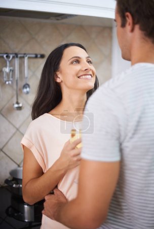 Photo for Toasting their future. A young woman holding a glass of wine and looking up at her boyfriend - Royalty Free Image