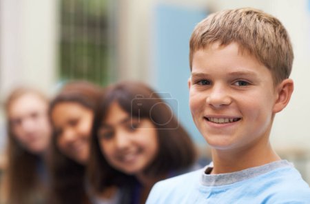 Foto de Mis amigos me hacen sonreír. Retrato de un joven escolar de pie con sus amigos borrosa en el fondo - Imagen libre de derechos