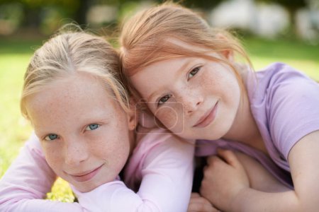 Téléchargez les photos : Étaient meilleurs amis. Deux petites filles allongées joyeusement sur l'herbe - en image libre de droit
