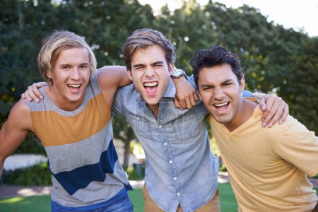 Photo for Friends for life. Portrait of three cheering friends standing with arms around each other in a park - Royalty Free Image
