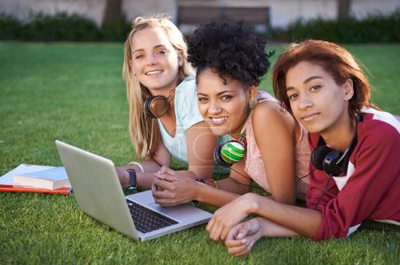 Photo for Group study session. Portrait of three smiling friends lying in a park and studying - Royalty Free Image