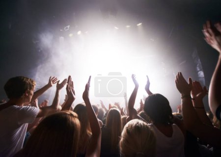 Concert, live music and people dancing at an event, party or nightclub with energy, freedom and fun. Band, musician or dj entertainment playing at music festival or rave at indoor venue with a crowd