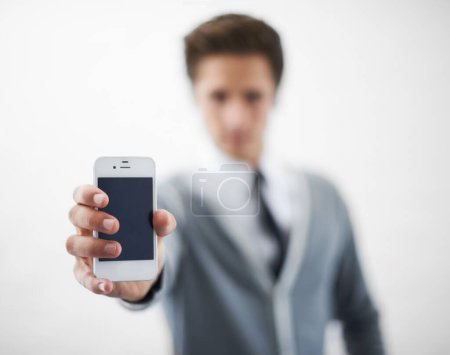 Photo for Presenting the newest smartphone. A young man holding his smartphone towards the camera - Royalty Free Image