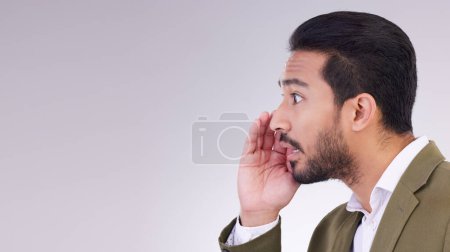 Mockup, secret and Asian man with gossip, whisper and talking against a grey studio background. Japan, male and guy with privacy, space and announcement with person, sharing opinion and mysterious.