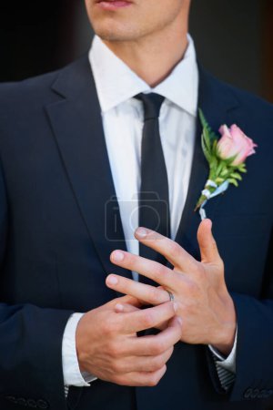 Photo for Hes a married man now. Closeup of a groom adjusting the ring on his finger nervously - copyspace - Royalty Free Image