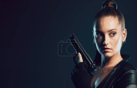 Photo for Woman, vigilante and gun in serious war, battle or agent standing ready for mission on mockup. Female spy holding weapon for secret operation, objective or cosplay against a dark studio background. - Royalty Free Image
