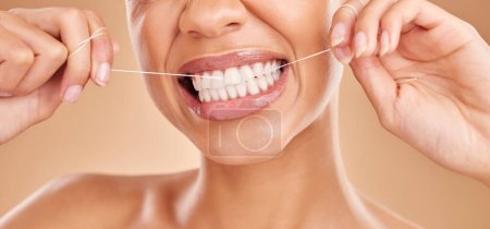 Foto de Flossing, sonrisa y una mujer con cuidado dental para los dientes aislados en un fondo de estudio. Feliz, cuidado de la salud y la boca de una niña con una rutina de limpieza de la higiene bucal, tratamiento y hilo dental. - Imagen libre de derechos