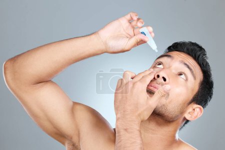 Eye drops can treat a range of eye problems. Studio shot of a man using eye drops