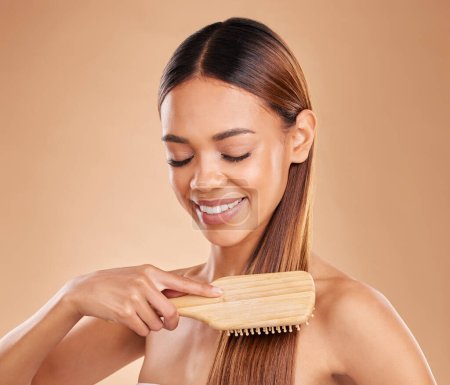 Photo for Woman, beauty and brushing hair for growth and shine for healthy texture on a brown background. Smile of aesthetic female happy in studio with a brush for natural keratin treatment haircare results. - Royalty Free Image