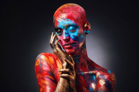 Photo for Step into my art world. an attractive young woman posing alone in the studio with paint on her face and body - Royalty Free Image