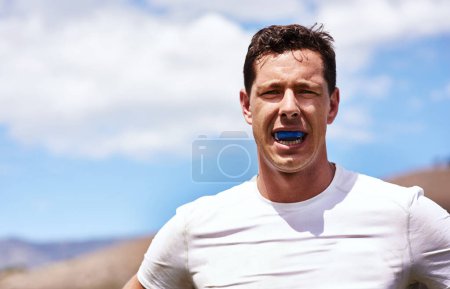 Pas de bleus sur les gencives. Portrait d'un jeune homme portant un chewing-gum lors d'un match de rugby
