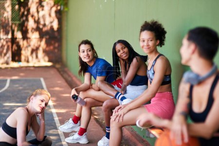 Photo for Having some girl talk on the court. a group of sporty young women chatting to each other on a sports court - Royalty Free Image