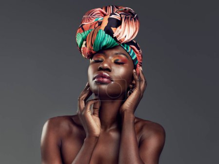 Rock your crown like the queen you are. Studio shot of a beautiful young woman wearing a traditional African head wrap against a grey background