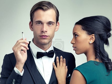 Photo for Caught in his web. A portrait of a dapper young man and his girlfriend in vintage evening wear - Royalty Free Image