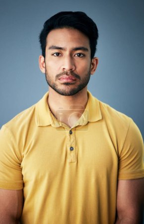 Confidence, serious and portrait of a man in studio with depression, sadness or mental health problem. Tired, exhausted and Indian male model with burnout face expression isolated by gray background