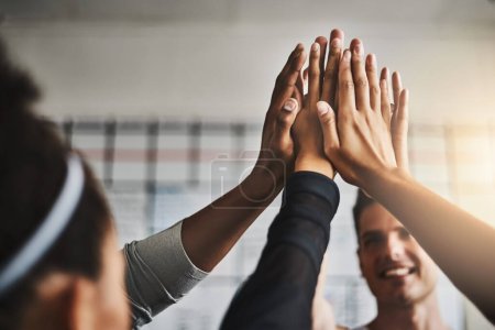 Photo for Stay together, stay motivated. a group of young people giving each other a high five during their workout in a gym - Royalty Free Image