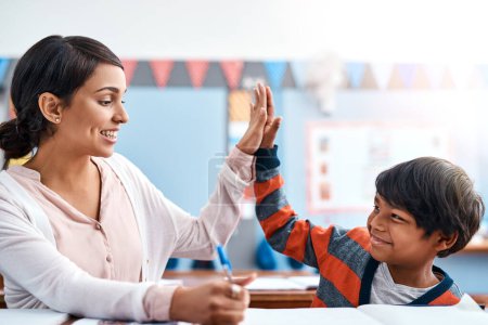 Foto de Estás genial hoy. una alegre profesora joven dándole a su alumna unos cinco por hacer un gran trabajo en el aula - Imagen libre de derechos