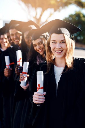 Photo for This is where our journey starts. Portrait of a group of students standing in a line on graduation day - Royalty Free Image