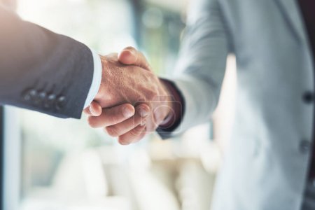 Photo for Merging for success. two unrecognizable businessmen shaking hands after making a deal in the office - Royalty Free Image