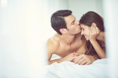 Romantic, love and man kissing his wife in the morning after an anniversary, date or intimate time in bed. Gratitude, relax and young couple in the bedroom showing care and bonding for valentines day. Poster #648041660