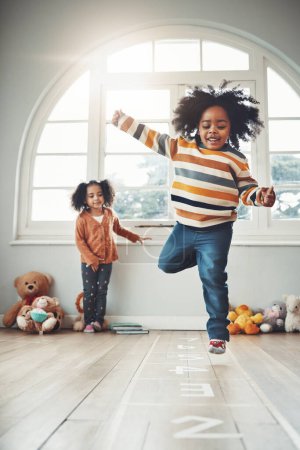 Photo for Hopscotch, games and children play in home having fun, enjoy entertainment and relax together in room. Childhood, happy and excited siblings in bedroom for jumping game, playing and activity on floor. - Royalty Free Image