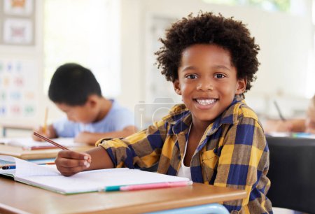 Photo for Education, drawing portrait or boy child in classroom learning, exam or studying with preschool notebooks. Development or kids or happy student with creative art writing for knowledge in kindergarten. - Royalty Free Image