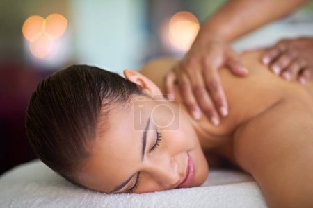 Foto de Es todo lo que un cuerpo puede pedir. una joven disfrutando de un masaje de espalda en un spa - Imagen libre de derechos