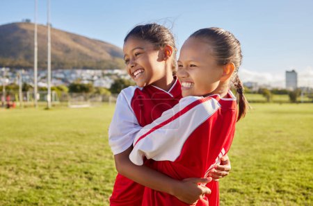 Photo for Football, girl and sports children hug, smile and happy together having fun, bond and enjoy outdoor game. Friends, young kids or teammates embrace on Brazil soccer field for youth academy training. - Royalty Free Image