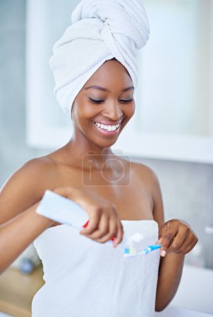 Foto de Manteniendo alejadas las cavidades. Retrato de una atractiva joven lavándose los dientes por la mañana - Imagen libre de derechos
